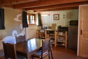 een eetkamer met een tafel en een keuken bij Gîtes calmes écologiques in Saint-Symphorien