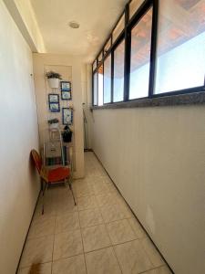 an empty hallway with a chair and a window at Porto das Dunas Apartment in Aquiraz