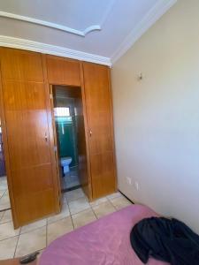 a bedroom with a bed and wooden cabinets at Porto das Dunas Apartment in Aquiraz