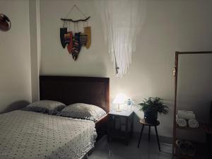 une chambre avec un lit et une table avec une lampe dans l'établissement Nhà mình Homestay, à Ấp Thanh Sơn (1)