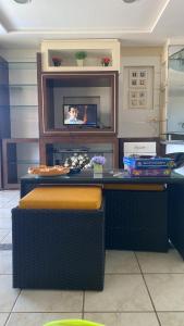 a kitchen with a counter with a tv on the wall at Porto das Dunas Apartment in Aquiraz