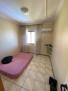 a room with a pink bed and a window at Porto das Dunas Apartment in Aquiraz