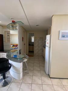 a kitchen with a glass table and a refrigerator at Porto das Dunas Apartment in Aquiraz +8 photos