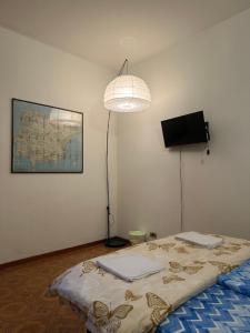 a room with a bed with a lamp and a tv at Bnb fantasia in Bologna