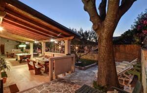une terrasse avec un arbre, une table et des chaises dans l'établissement Luxury villa with a swimming pool Skrip, Brac - 17350, à Postira