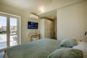 a bedroom with a large bed and a balcony at Villa Mila with private pool, BBQ and jacuzzi in Strpačići +18 photos