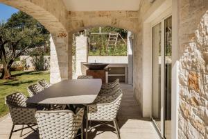 an outdoor patio with a table and chairs at Villa Mila with private pool, BBQ and jacuzzi in Strpačići