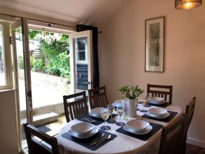a dining room table with chairs and a table set for dinner at Church View Cottage & Barn in Hatherleigh