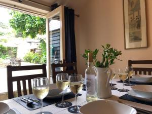 a table with wine glasses and a bottle of wine at Church View Cottage & Barn in Hatherleigh