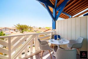 Un patio con una mesa y sillas en un balcón. en Duplex Biscarrosse plage pour 4 Personnes, en Biscarrosse