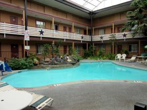a large pool in the courtyard of a hotel at Budget Host Inn in Arlington