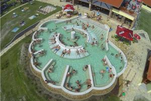 Una gran piscina con gente en el agua. en Vörös Álom Apartman Panzió, en Tiszakécske