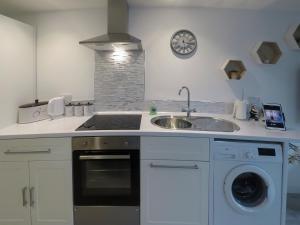a kitchen with a sink and a stove top oven at The Secret Luxury Apartment in New Romney