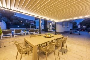 a patio with a wooden table and chairs at Holiday house with a swimming pool Baska, Krk - 21537 in Baška