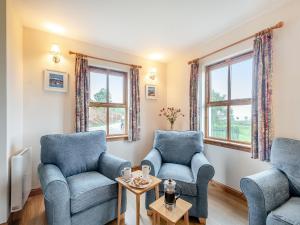 a living room with two chairs and a table at Cruinn in Taynish