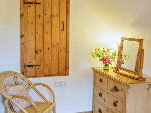 Habitación con tocador con espejo y silla en East Granary - 28956, en Eye