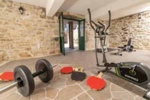 una sala de fitness con un gimnasio con pesas y una cinta de correr en Family friendly house with a swimming pool Zastrazisce, Hvar - 23743, en Zastražišće