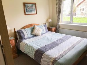 a bedroom with a bed and a window at Kestral in Welney