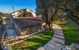 a stone house with trees and a stone path at Holiday house with a parking space Sveti Jakov, Losinj - 24017 in Sveti Jakov +16 photos