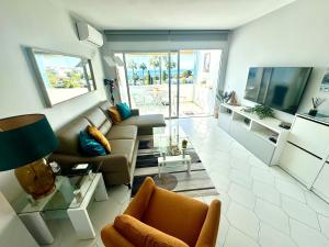 a living room with a couch and a tv at Amazing sea view apartment in Miraflores in La Cala de Mijas