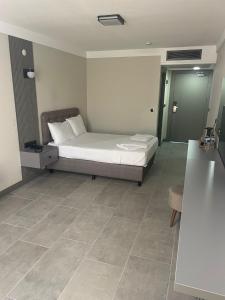 a bedroom with a bed and a tile floor at Grand Cennet Beach Hotel in Akcay