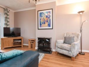 a living room with a couch and a chair and a fireplace at Oyster Catchers - Uk6730 in Lydstep