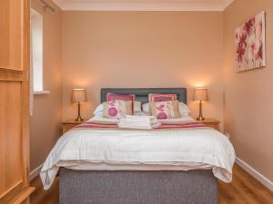 a bedroom with a large bed with pink pillows at Oyster Catchers - Uk6730 in Lydstep