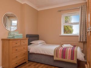 a bedroom with a bed with a dresser and a window at Oyster Catchers - Uk6730 in Lydstep +5 photos