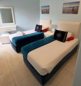 ダーバンにあるSea Lodge G01の青と白のベッド2台が備わる客室です。