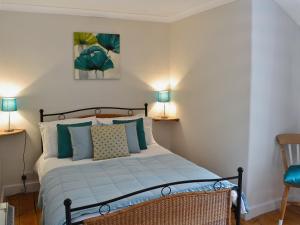 a bedroom with a bed and two lamps at Gewans Farm Cottage in St Austell