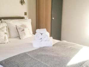a pile of towels sitting on top of a bed at Ebba's Neuk in Beadnell