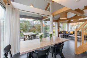 a dining room with a wooden table and chairs at Zonnedorp 22 Vakantiehuis Anoes Renesse | Strandnabij Comfort in Zeeland in Renesse