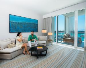een man en vrouw zittend op een bank in een woonkamer bij Hyatt Regency Aqaba Ayla Resort in Aqaba