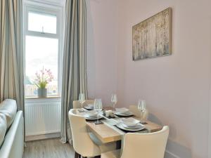 een eetkamer met een tafel en stoelen bij Elfin Cottage - Uk7810 in Coirantee