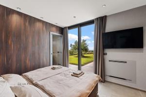 a bedroom with a bed and a flat screen tv at Villa Visignano with private pool, BBQ and jacuzzi in Strpačići +38 photos