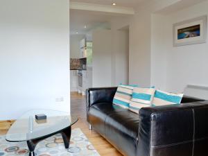 a black leather couch in a living room with a table at Lunga - 28791 in Clachan