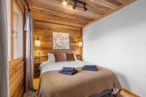 two beds in a room with wooden walls at Silverfox - 6 pers - belle vue in Plan Fey