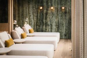 a waiting room with white couches and yellow pillows at Forster's Naturresort in Neustift im Stubaital +98 photos