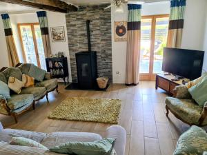 un soggiorno con divani e TV a schermo piatto di Maison Trichard a Brillac