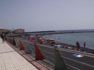 una playa con gente en la arena y el agua en Residencial la Gomera, en Puertito de Güímar