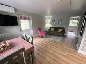 a living room with a table and a couch at Little Pear Tree in Stock