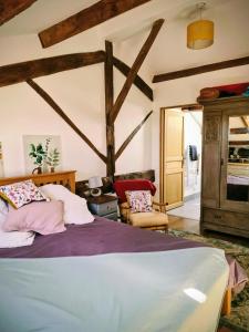 una camera da letto con un letto e una sedia in una stanza di Maison Trichard a Brillac