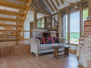 a living room with a couch and a table at Norwood Barn in Maidstone
