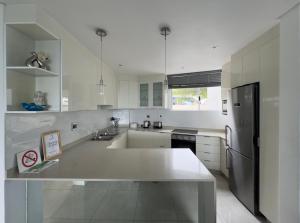 a white kitchen with a sink and a refrigerator at Sea Lodge G01 in Durban