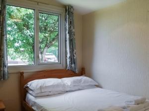 ein Schlafzimmer mit einem Bett und einem Fenster in der Unterkunft Gunner Head - Uk47557 in Saint Merryn