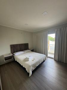 a bedroom with a large bed and a large window at Alquileres temporales in Junín