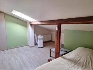 a bedroom with a bed and a green wall at Petite maison proche cathédrale centre 3 pers in Toul +1 photo