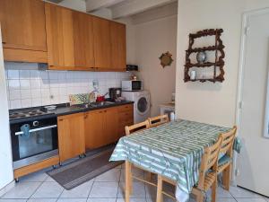 a small kitchen with a table and a microwave at Petite maison proche cathédrale centre 3 pers in Toul