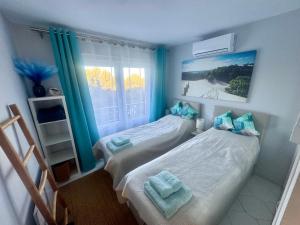 two beds in a small room with a window at Amazing sea view apartment in Miraflores in La Cala de Mijas +58 photos