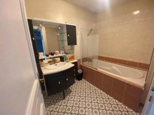 Un baño con bañera, lavabo y bañera. en L'Hippodrome d'Arras - Appartement 3 chambres, en Arras